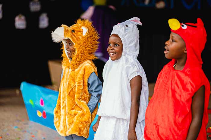 Three pre school students sing